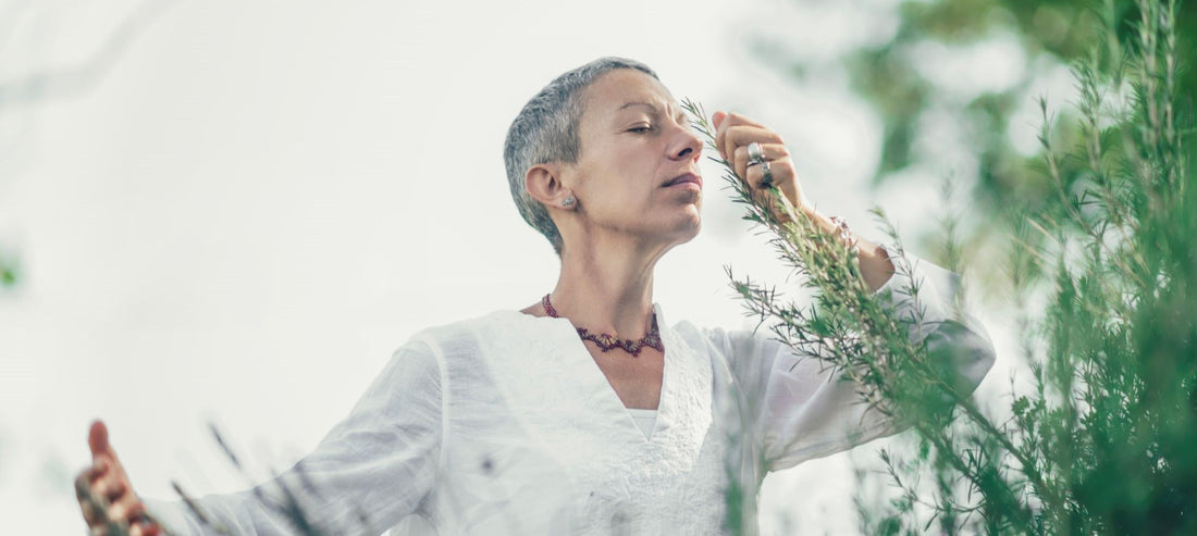 woman breathing in the scent of a flower