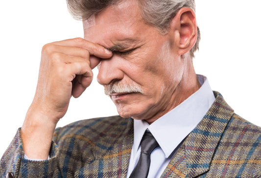 Older man with a headache behind his eyes