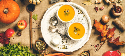 pumpkin soup on table with other fall vegetables